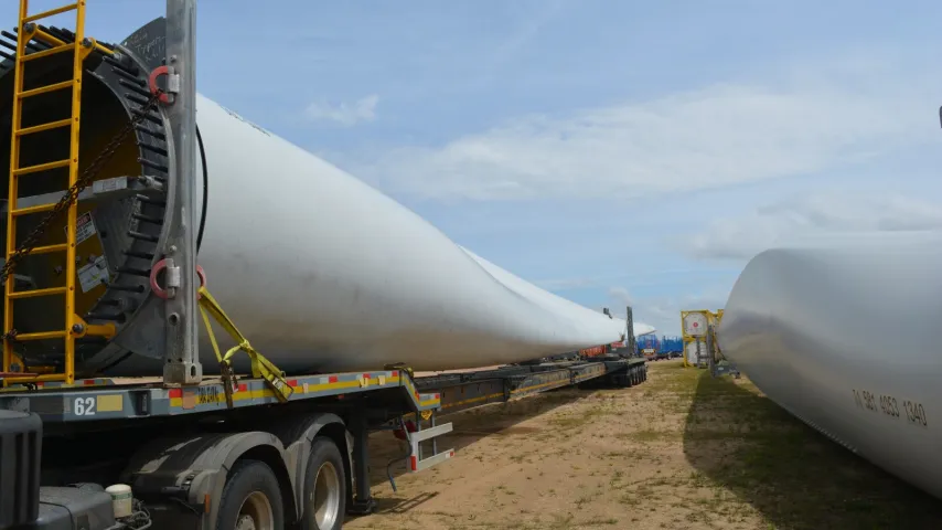 Vista parcial de 2 aspas de molinos para generación eléctrica cargados en camiones